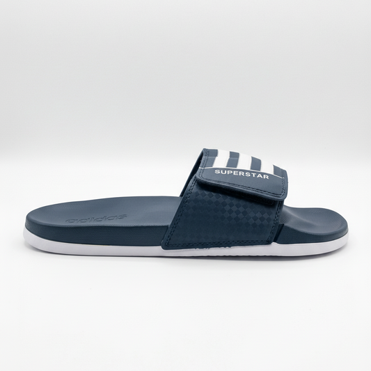 Adidas Superstar slide azul marino vista lateral profesional fondo blanco gris claro 3 rayas blancas verticales SUPERSTAR blanco velcro checker azul marino footbed azul marino adidas relieve izquierda suela blanca delgada