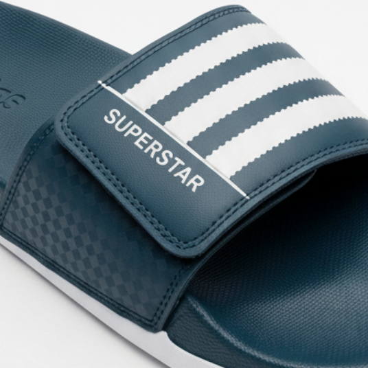Adidas Superstar slide azul petróleo teal vista detallada angular 3/4 frontal-derecha correa 3 rayas blancas horizontales serradas SUPERSTAR blanco izquierdo velcro checker footbed azul petróleo adidas relieve izquierda suela blanca gruesa prominente